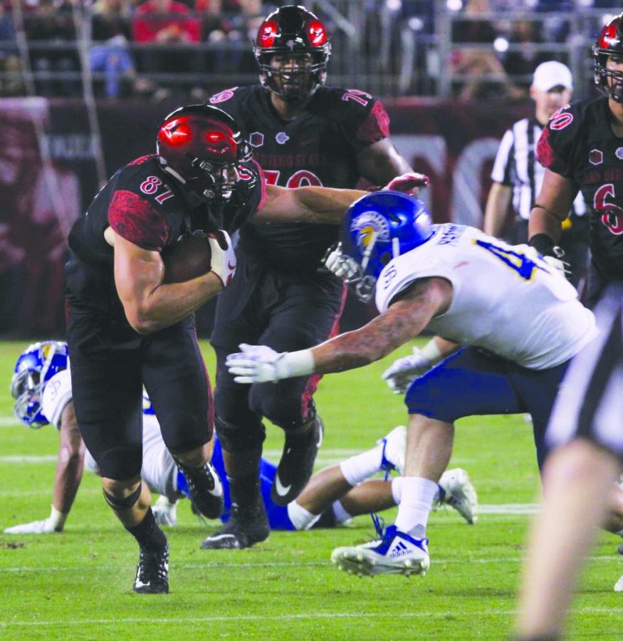 Kahale Warring stiff arms a defender against San José State on Oct. 20, 2018 at SDCCU Stadium.