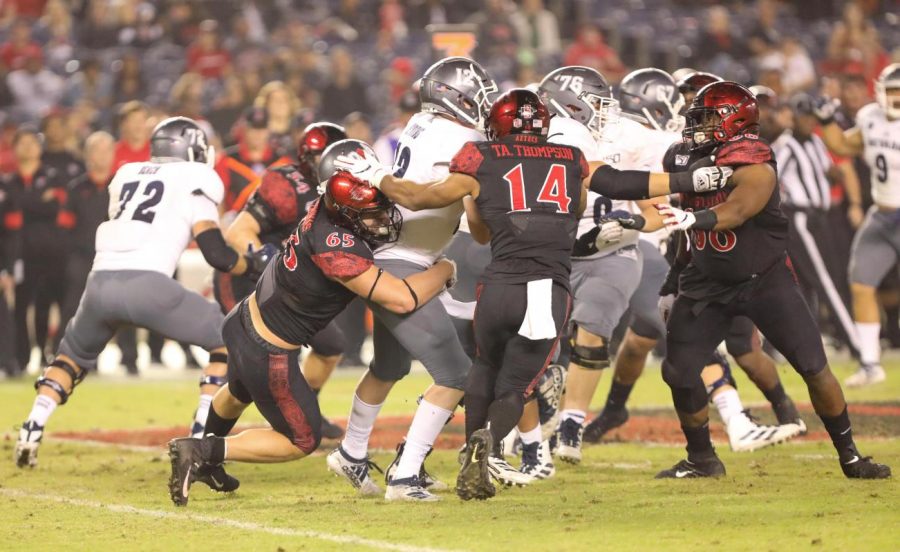 Then-freshman defensive lineman Cam Thomas and then-junior defensive back Tariq Thompson surround Nevada then-freshman quarterback Carson Strong for a sack during the Aztecs' 17-13 loss to the Wolf Pack on Nov. 9, 2019 at SDCCU Stadium.
