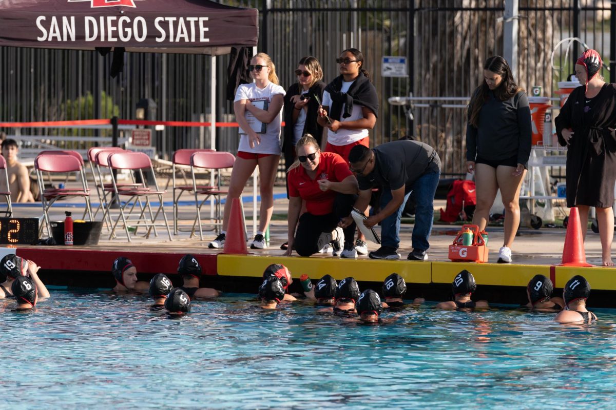 Head coach Dana Ochsner and assistant coach Randy Galza debrief with the team during the end of the second period against Stanford last season at the Aztec Aquaplex.