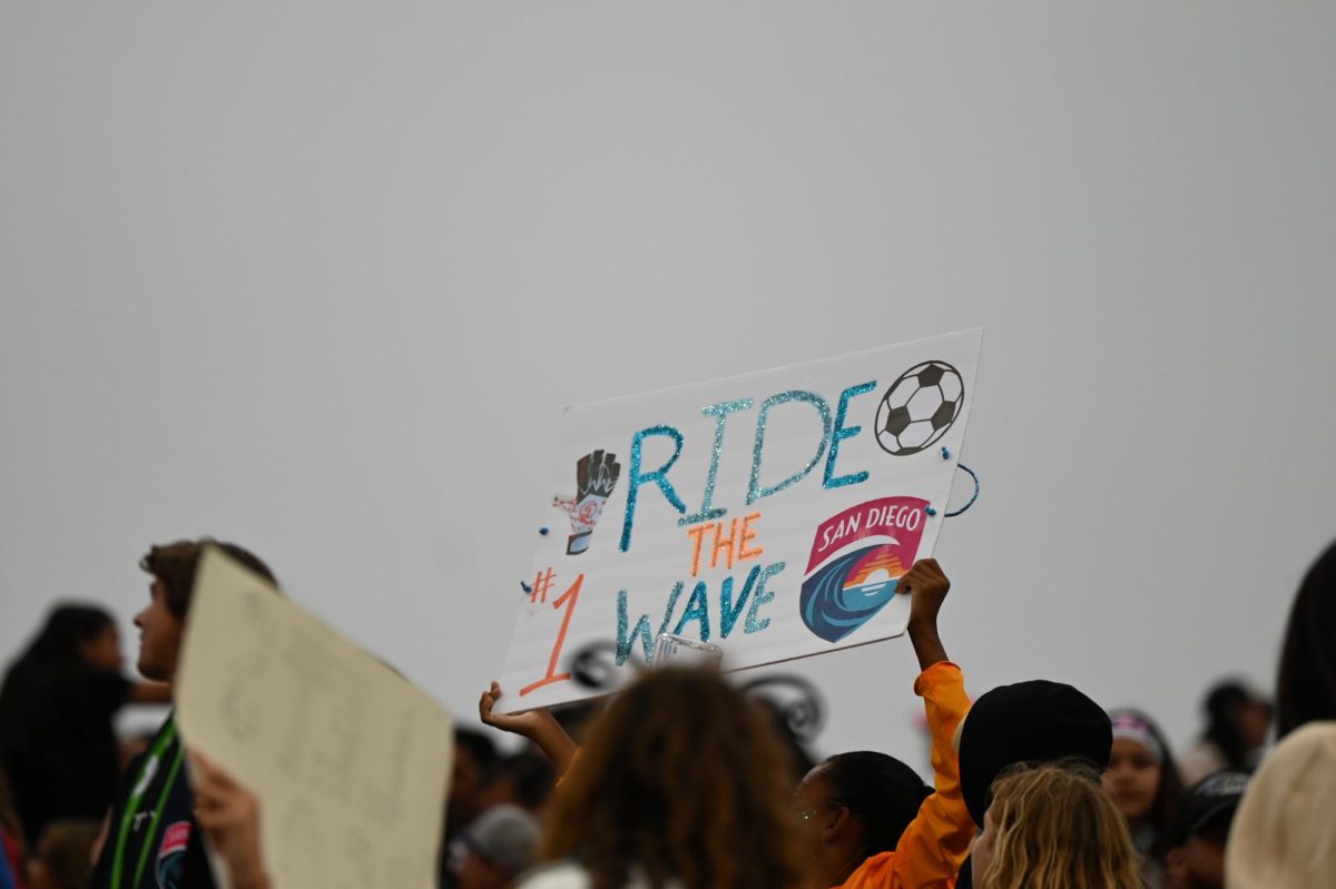 A San Diego Wave FC sign reading "ride the wave" stands out amongst the fans during their match against Seattle Reign FC on Friday June 6, 2025 at Snapdragon Stadium