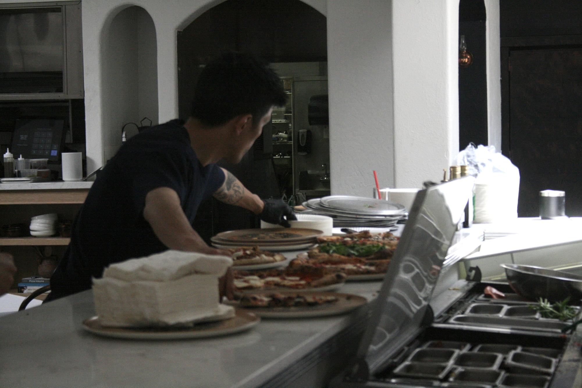 Chef prepares a wide selection of pizza inside of Bosforo, a modern Turkish restaurant in Normal Heights